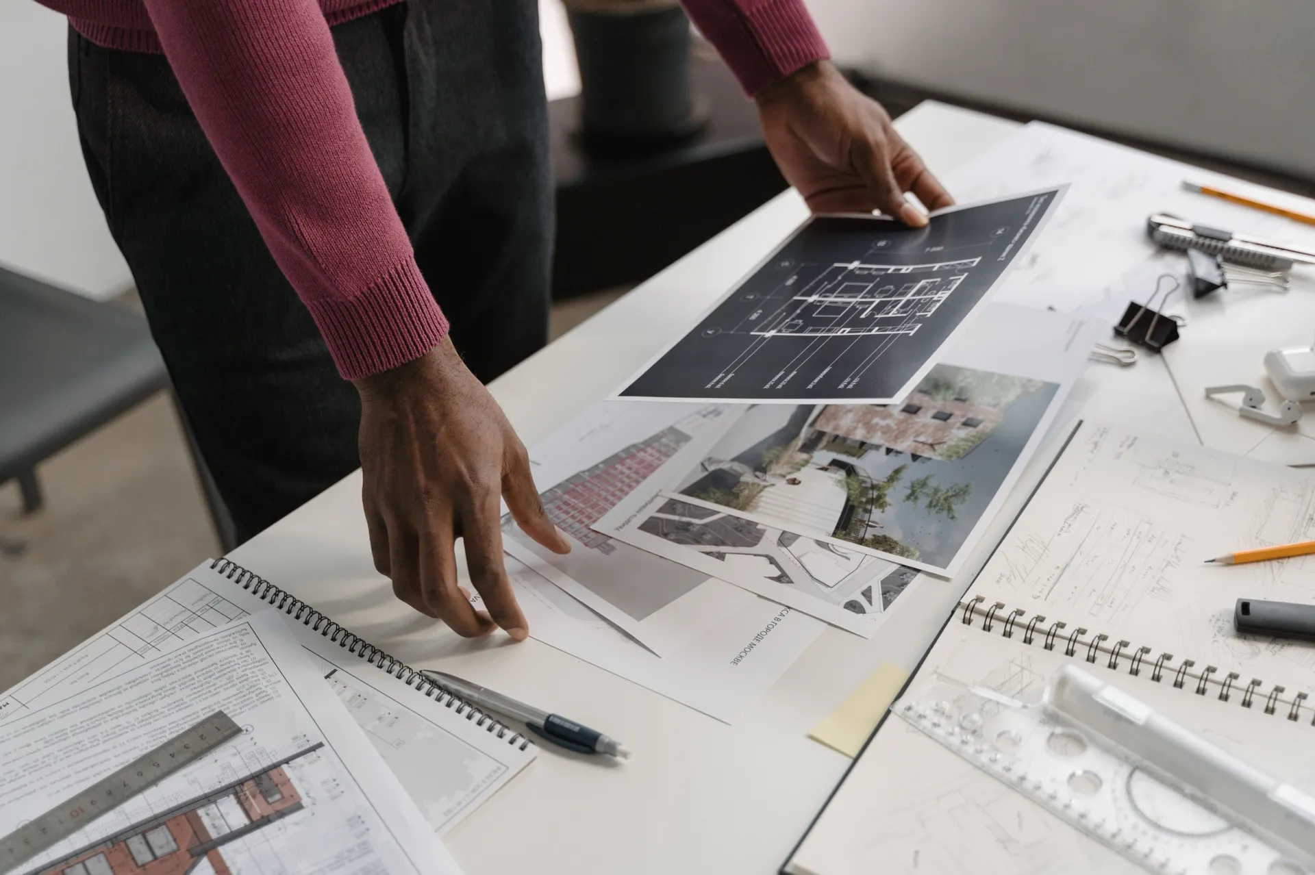 Plans architecturaux et esquisses consultés sur une table de travail, photo d'illustration